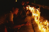 Myanmar (Burma), Kyaiktiyo, Buddhist pilgrims lighting candles at 'golden rock'. - Martin Westlake