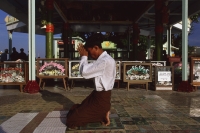 Myanmar (Burma), Kyaiktiyo, Buddhist pilgrim praying at 'golden rock'. - Martin Westlake