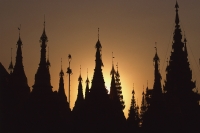 Myanmar (Burma), Yangon, Shwedagon Paya, Silhouette of stupa tops at sunset. - Martin Westlake