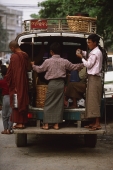 Myanmar (Burma), Mandalay, Men in longyis standing at back of public minivan. - Martin Westlake