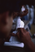 Myanmar (Burma), Mandalay, Craftsman painting marble Buddha statue. (Grainy) - Martin Westlake