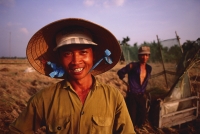 Vietnam, Outside Vinh Long, Mekong delta, Smiling rice farmers at rice harvest / threshing time. - Martin Westlake