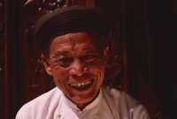 Vietnam, Tay Ninh, Caodist devotee in front of door at Holy See Temple. - Martin Westlake