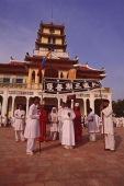 Vietnam, Tay Ninh, Funeral flag bearers and devotees outside Holy See Temple. - Martin Westlake