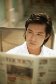 Young man reading newspaper - Alex Microstock02