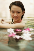 Young woman in swimming pool, looking at camera, smiling - Alex Microstock02