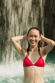 Young woman in swimming pool, water cascading on her - Alex Microstock02