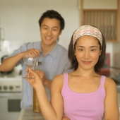 Couple in kitchen, man opening wine bottle, woman holding wine glass - Eckersley/Peacock