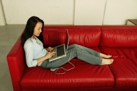 Woman on sofa, using laptop - Eckersley/Peacock