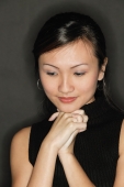 Young woman wearing a black top, hands clasped - Alex Microstock02