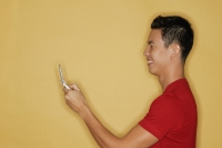 Young man holding mobile phone, profile - Alex Microstock02