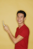Young man holding mobile phone, looking at camera - Alex Microstock02