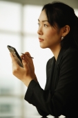 Young woman sitting at desk, using PDA - Alex Microstock02