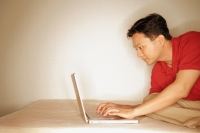 Man using laptop, sideview - Alex Microstock02