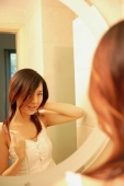 Woman touching her hair, looking at mirror - Alex Microstock02