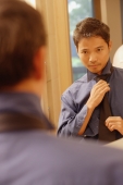 Young man  looking in mirror, adjusting tie - Alex Microstock02