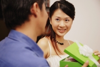 Young man and woman holding gift box, looking at each other - Alex Microstock02