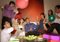 Group of friends having a party at home, holding balloons - Alex Microstock02