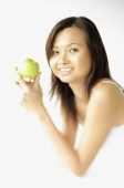Young woman lying on floor, holding apple, smiling at camera - Alex Microstock02