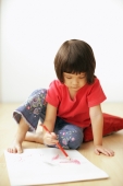 Young girl drawing on drawing pad, sitting on floor - Alex Mares-Manton