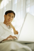 Young man using laptop, focus on the background - Alex Microstock02