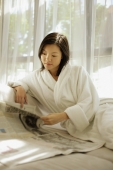Young woman wearing robe, reading newspaper - Alex Microstock02