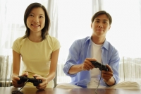 Young couple side by side, playing with handheld video game - Alex Microstock02