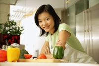 Young woman leaning on kitchen counter, looking at camera - Alex Microstock02