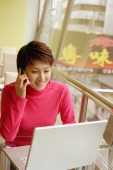 Young woman using laptop and mobile phone - Alex Microstock02