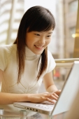 Young woman using laptop, smiling - Alex Microstock02