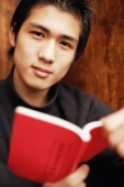 Young man holding book, looking at camera - Alex Microstock02