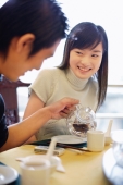 Young man pouring tea for young woman - Alex Microstock02