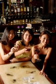 Three women sitting around table with wine glasses - Alex Microstock02