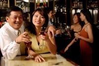 Couple looking at camera, holding wine glasses - Alex Microstock02