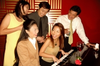 Woman playing the piano, friends around her - Alex Microstock02