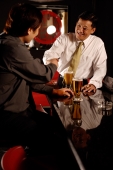 Two men shaking hands, beer glasses on table. - Alex Microstock02