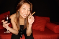Woman holding wine glass and cigar, looking at camera - Alex Microstock02