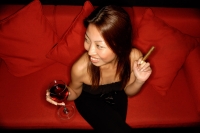 Woman holding wine glass and cigar, elevated view - Alex Microstock02