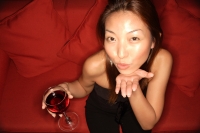 Woman holding wine glass and blowing kiss at camera - Alex Microstock02