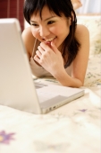  Young woman in bedroom using laptop - Alex Microstock02