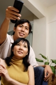 Couple at home, man holding remote control - Alex Microstock02