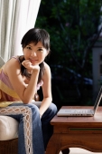 Woman with laptop, looking at camera, hand on chin - Alex Microstock02