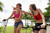 Two women on bicycles, one woman pointing - Alex Microstock02