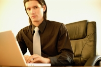 Executive in office using laptop, portrait - Alex Microstock02