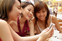 Three young women looking at mobile phone - Alex Microstock02