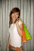  Young woman holding shopping bags over shoulder, smiling - Alex Microstock02
