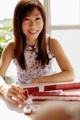 Woman smiling, mahjong tiles in front of her - Alex Microstock02