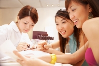 Young women having their nails painted at nail salon - Alex Microstock02