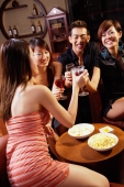 Three young women and a man in entertainment club, toasting with drinks - Alex Microstock02