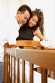  Couple standing over crib, looking down - Alex Microstock02